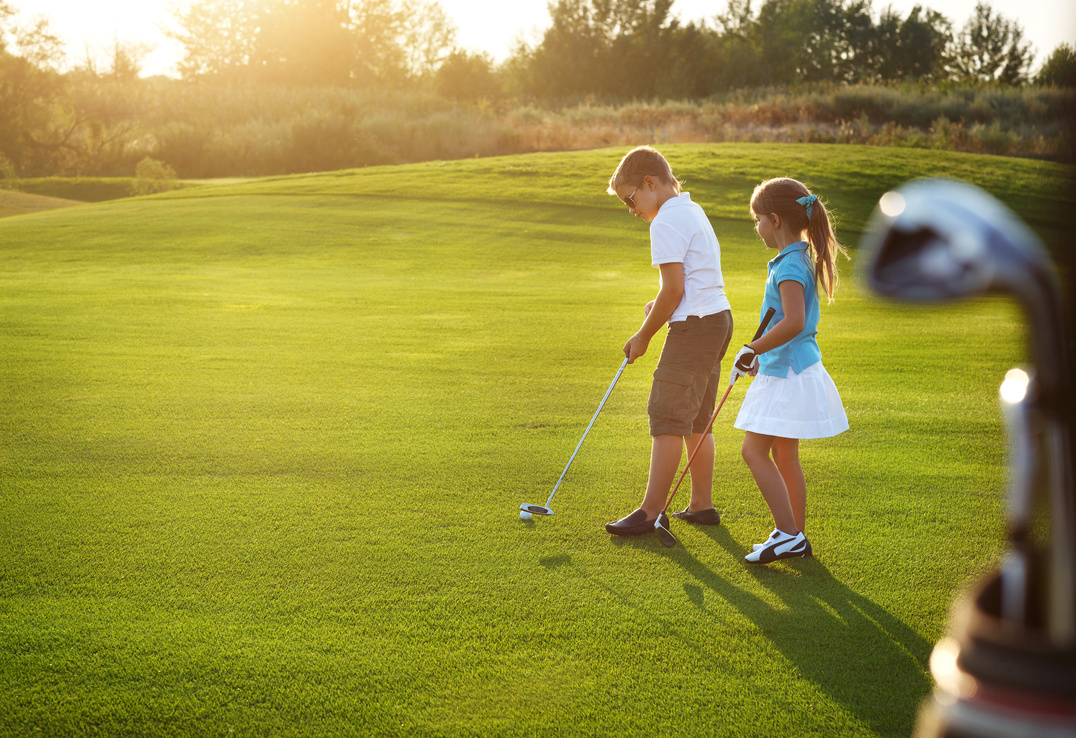 Casual Kids at a Golf Field Holding Golf Clubs